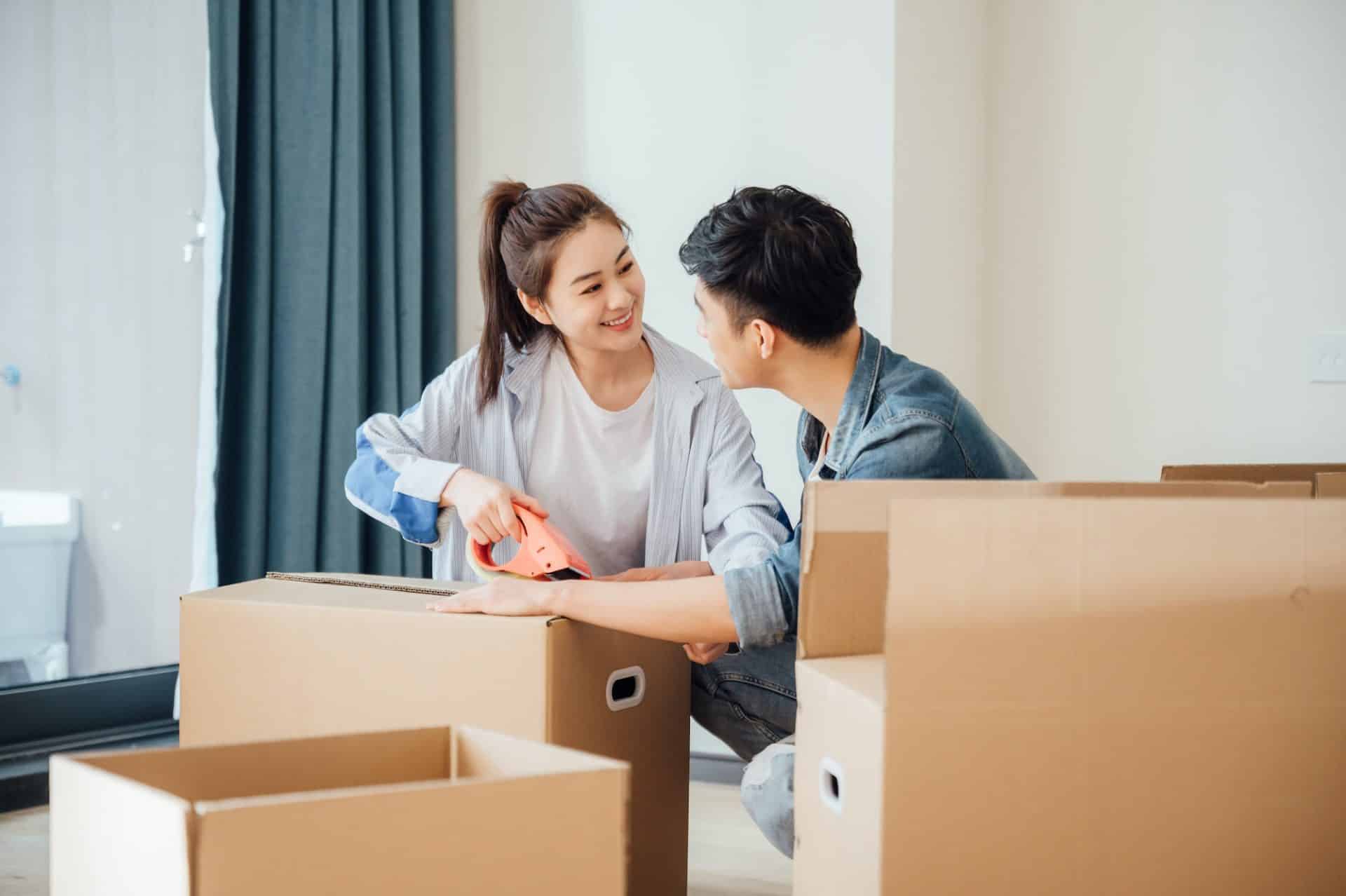 Young couple moving boxes in new home