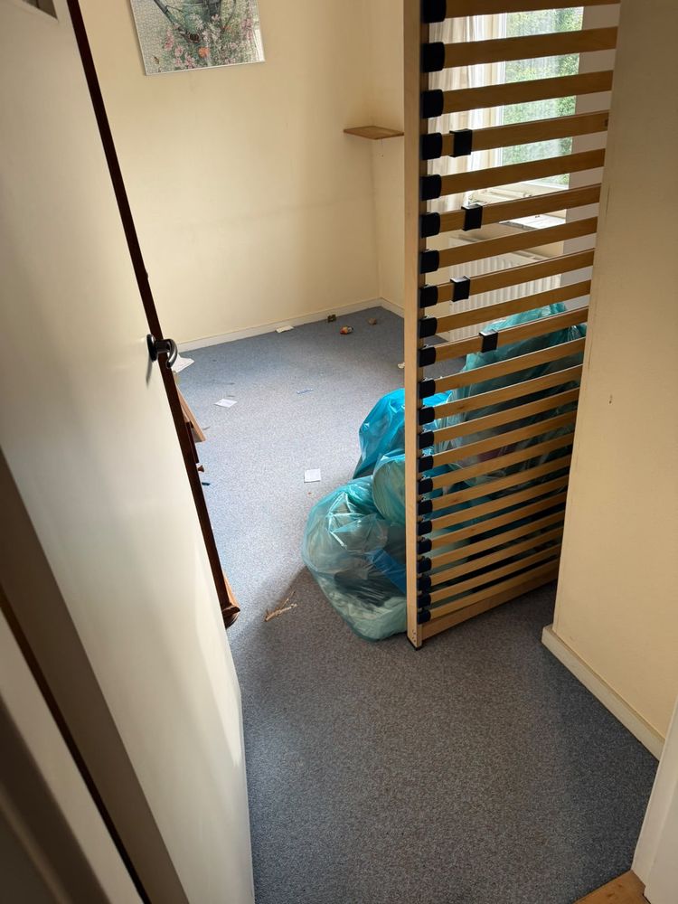 Kleine slaapkamer in Breukelen voor de ontruiming, met lattenbodem en vuilniszakken