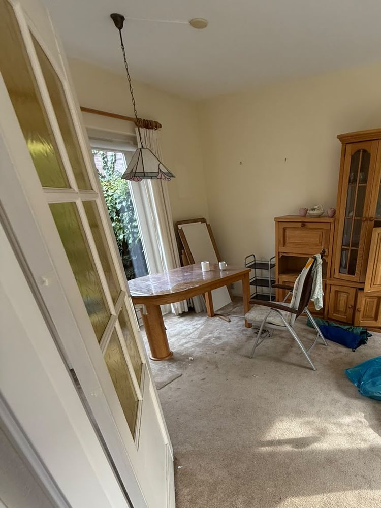 Woonkamer in Breukelen voor de ontruiming, met kast, tafel en stoelen