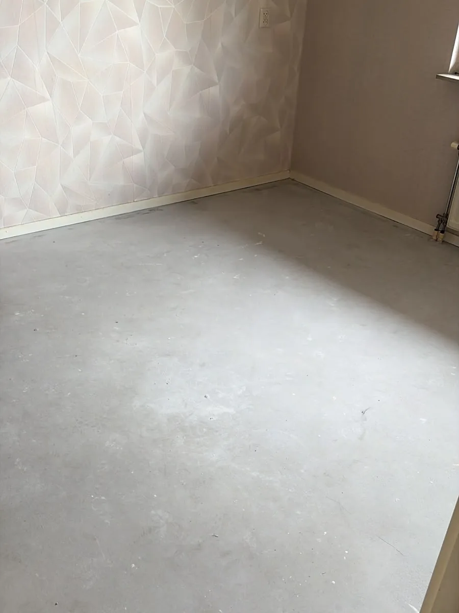 Dezelfde slaapkamer in Vlaardingen na de ontruiming: leeg en de vloerbedekking verwijderd